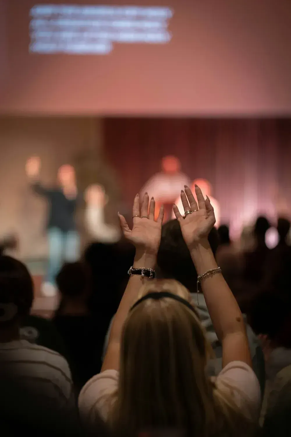 A woman lifting her hands in worship during a Sunday gathering